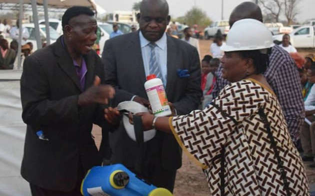 Minister of State for Manicaland Provincial Affairs Mandi Chimene hands over a knapsack sprayer to a cattle farmer during the official opening of Molus Abattoir